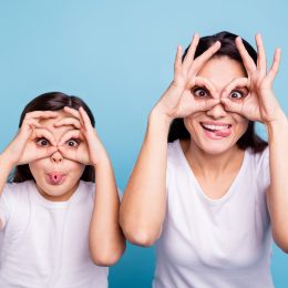 mom and daughter making silly faces and telling stupid jokes together