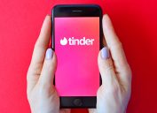 woman holding her phone with the tinder app open
