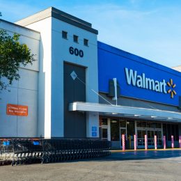Walmart store facade. Row of shopping carts are ready for customers. Anti ram raiding bollards secure Wal-mart entrance from accident or theft