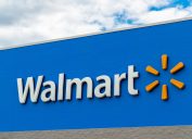 A Walmart sign in front of the store on a blue background