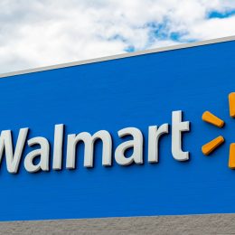 A Walmart sign in front of the store on a blue background