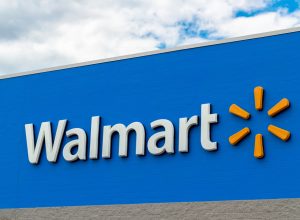 A Walmart sign in front of the store on a blue background