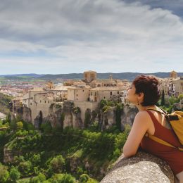Horizontal view of unrecognizable woman with backpack on holidays looking at the ancient Spanish city of Cuenca.
