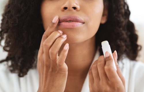 Woman applying moisturizing chapstick on lips