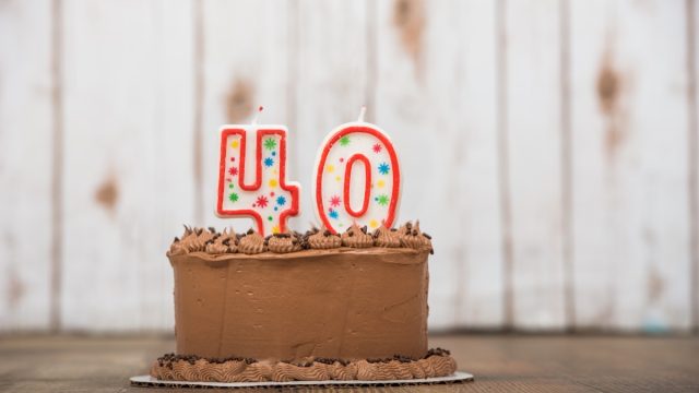 Chocolate frosted cake with 40 or forty candles on it for a 40th birthday or anniversary