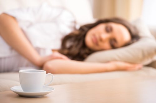 Woman Napping Next to Cup of Coffee