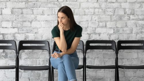 Young Woman Sitting Alone Feeling Tense or Anxious
