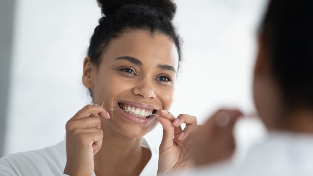 Young Woman Flossing her Teeth
