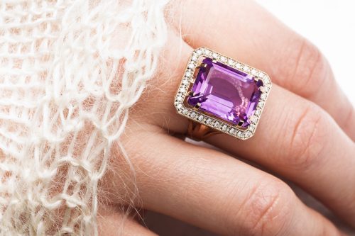 Close up of a large amethyst ring on a woman's hand