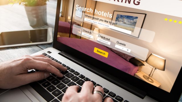 Close up of a computer screen and someone booking a hotel reservation