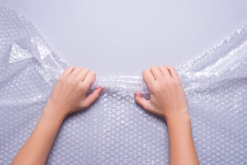 pair of hands pulling at bubble wrap