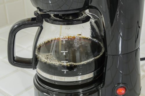 Close up of a black coffee maker brewing coffee