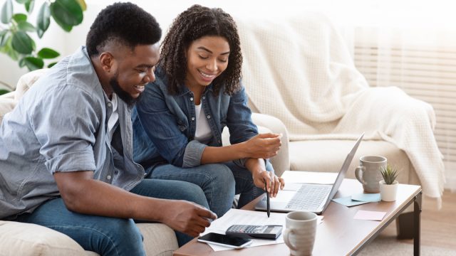 Household Budget. Smiling Black Couple Discussing Total Amount Of Their Spends At Home, Happy About Wise Planning