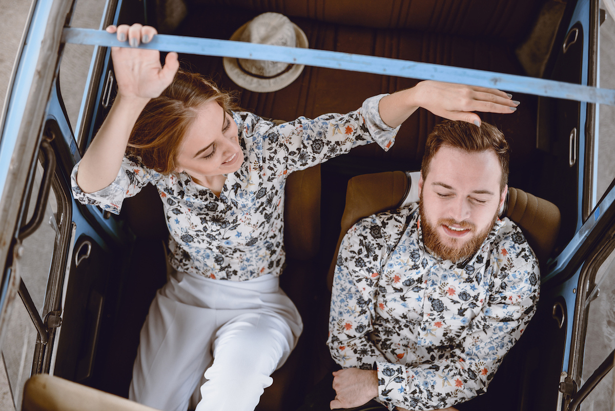 Happy couple in a vintage car wearing matching shirts