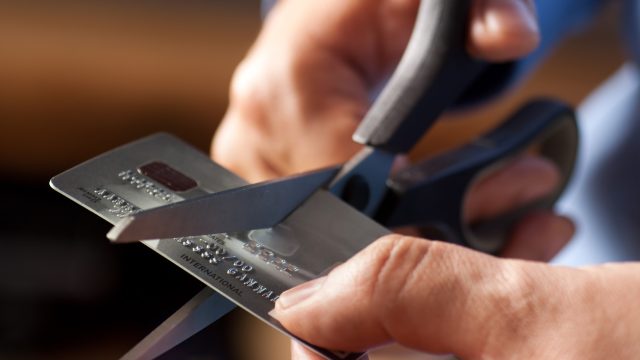 Closeup of someone cutting a credit card with a pair of scissors