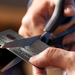 Closeup of someone cutting a credit card with a pair of scissors