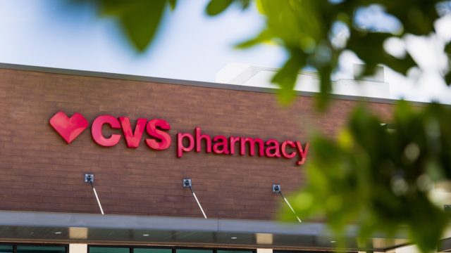 A CVS Pharmacy overlooks an empty parking lot on a hot summer day.