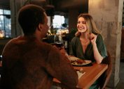 A young happy woman is in a restaurant on a Valentines date with her boyfriend.