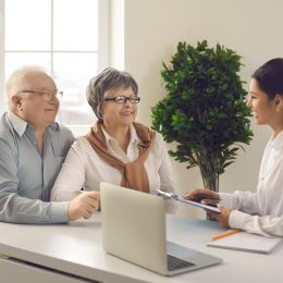 Two retirees talk to a tax consultant in a well lit room.