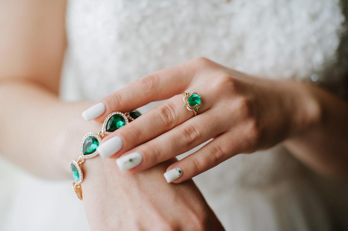 Close up of a bride wearing an emerald bracelet and ring
