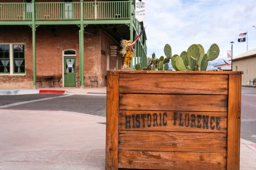 Historic Florence is stenciled on a planter with cactus growing in it on a street corner downtown.