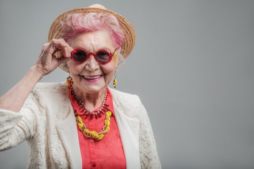 Funny older lady with pink hair looking at camera