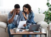 Family Financial Crisis Concept. Depressed Couple Looking At Invoice, Not Able To Pay Huge Bills
