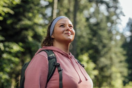 beautiful young woman hiking in nature, smile, optimistic about the future
