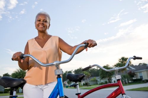 mujer mayor en la parte superior de color naranja pálido con bicicleta