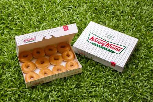 krispy kreme donuts in a box on the grass