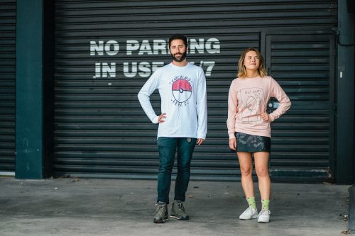 Models wearing graphic tees from Lonely Kids Club, standing in front of a garage door