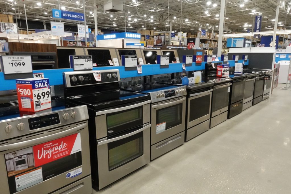 A row of stoves for sale at Lowes hardware store appliance department.