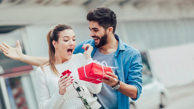 Romantic Man giving flower and gift box to woman for valentines day