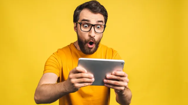 man looking surprised while reading weird body facts on his phone