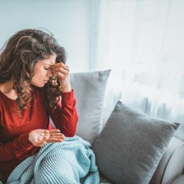 Close up image woman holding round pill and glass of still water taking painkiller to relieve painful feelings migraine headache, antidepressant or antibiotic medication, emergency treatment concept