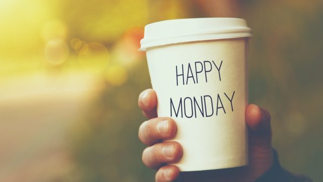 hand holding a cup that says "happy monday"