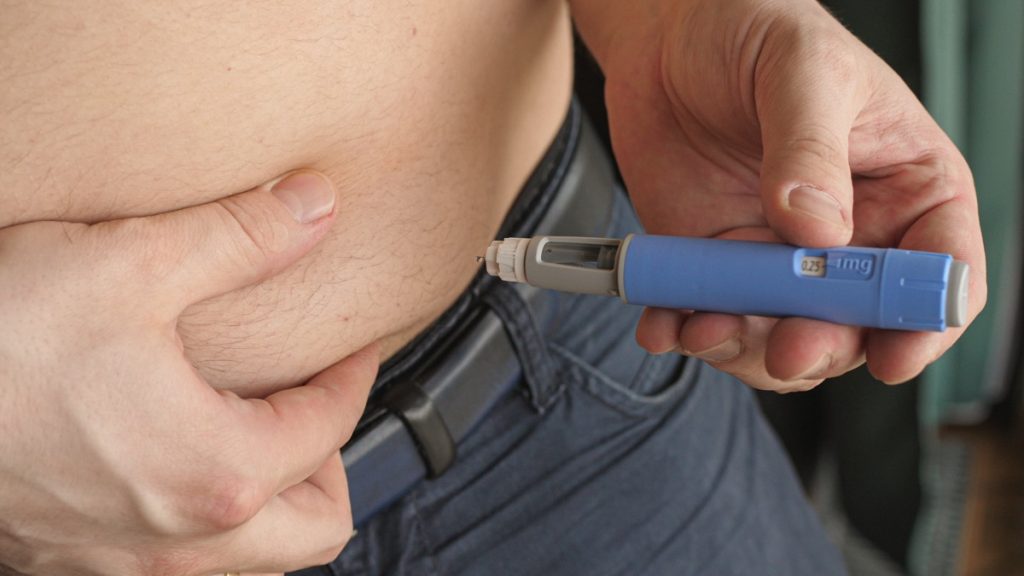 man with diabetes injecting Ozempic into his abdomen