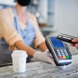 Close up of a person paying for a coffee with a card