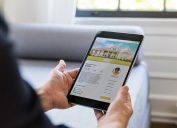 An unrecognizable man uses a real estate mobile app in his search for a new home.