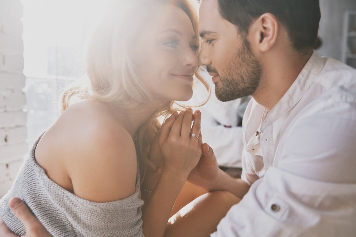 man and woman enjoying a romantic embrace in the sunlight