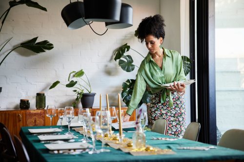 A woman setting a dining room table