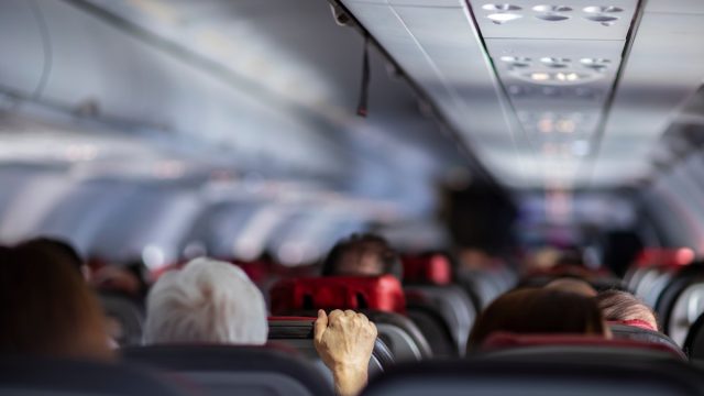 man holding airplane seat turbulence