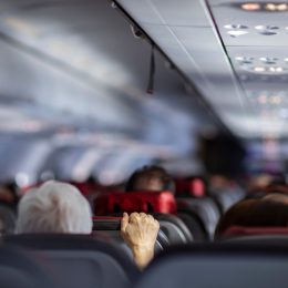 man holding airplane seat turbulence
