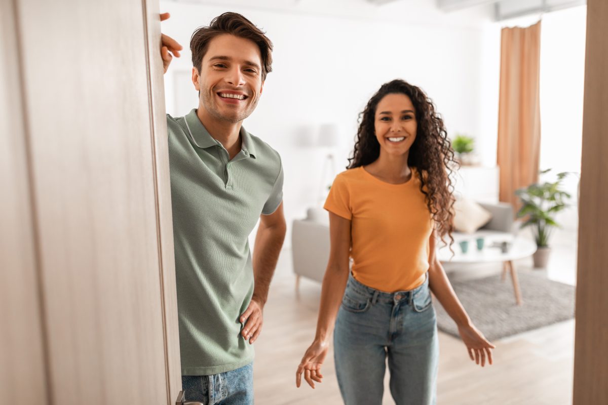 Couple welcoming guests into their home