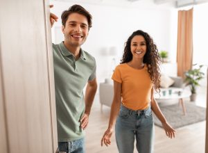 Couple welcoming guests into their home