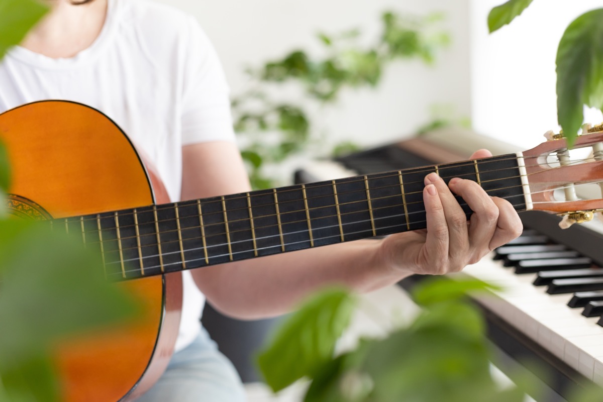 playing guitar among houseplants