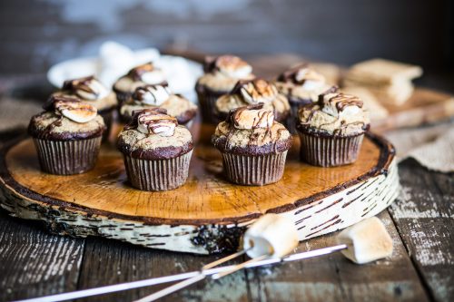 S'mores cupcake on a round wooden tray