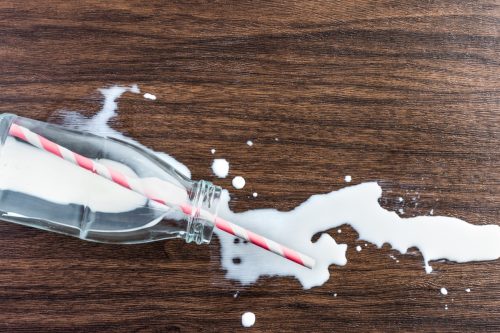bottle of spilt milk on wooden table