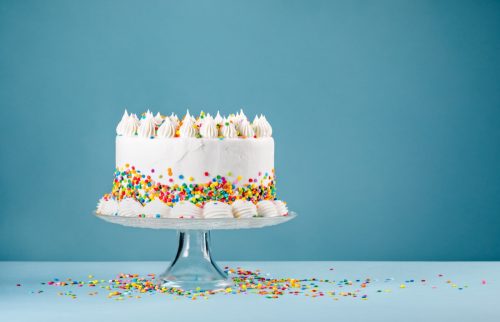 decorated cake with sprinkles in front of blue background