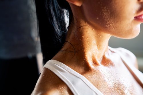 close up of a woman's shoulders covered in sweat